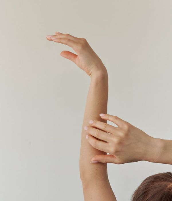 Woman in a graceful yoga pose against a light, clean background.